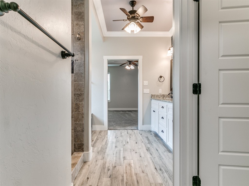 26812 Bridlewood Road, Blanchard, OK 73010 bathroom featuring ornamental molding, ceiling fan, vanity, and hardwood / wood-style flooring