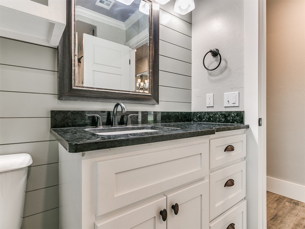 26812 Bridlewood Road, Blanchard, OK 73010 bathroom with hardwood / wood-style flooring, crown molding, toilet, and vanity