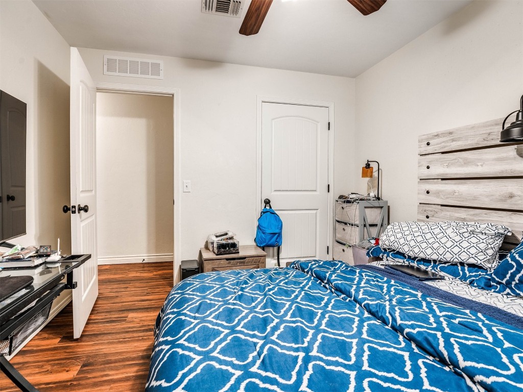 1113 SW 155th Street, Oklahoma City, OK 73170 bedroom with ceiling fan and dark hardwood / wood-style flooring