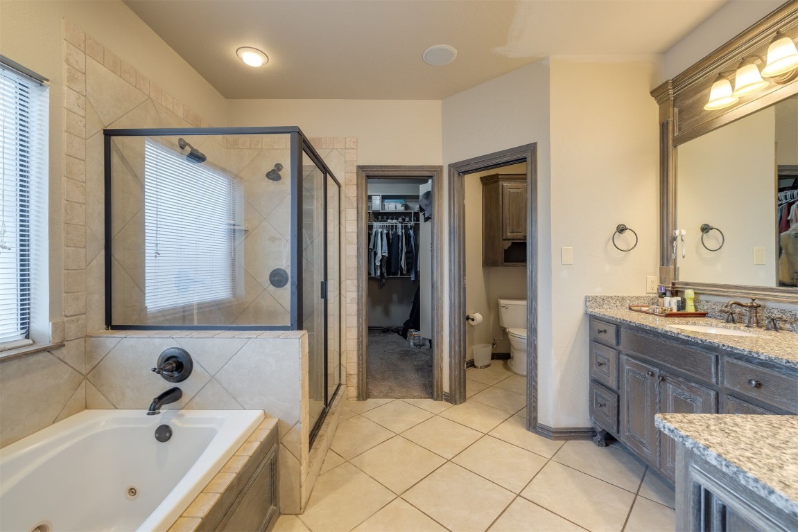 10901 Hunters Pointe, Edmond, OK 73034 full bathroom featuring tile flooring, vanity, toilet, and plus walk in shower