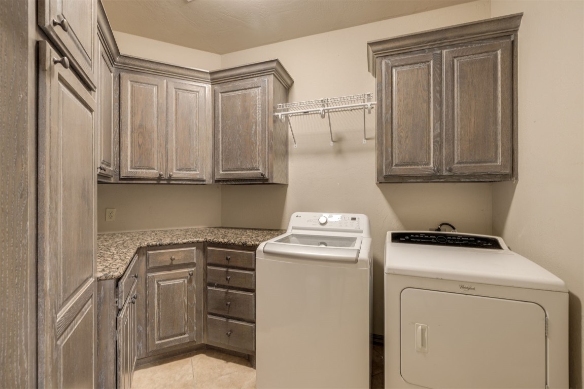 10901 Hunters Pointe, Edmond, OK 73034 laundry area featuring cabinets, independent washer and dryer, and light tile flooring