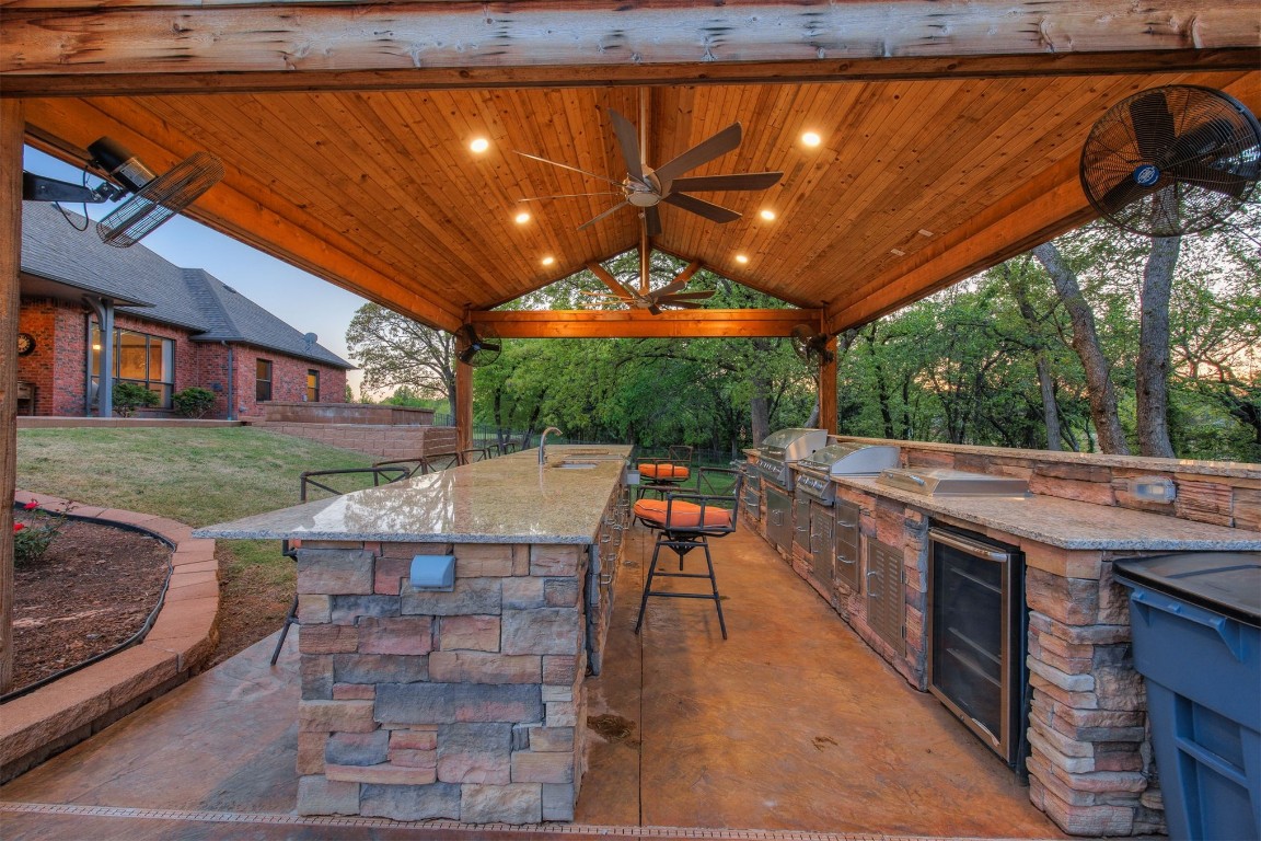 10901 Hunters Pointe, Edmond, OK 73034 view of patio / terrace with wine cooler, area for grilling, ceiling fan, and a gazebo