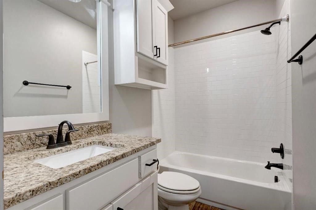 6301 NW 153rd Street, Edmond, OK 73013 full bathroom featuring vanity, tiled shower / bath combo, and toilet