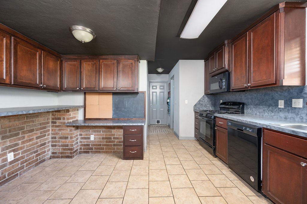 205 Vickie Drive, Del City, OK 73115 kitchen featuring tasteful backsplash, black appliances, and light tile flooring
