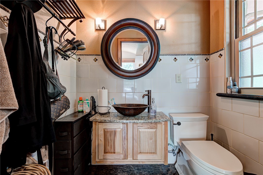 7900 N Bryant Avenue, Oklahoma City, OK 73131 bathroom featuring vanity, backsplash, toilet, and tile walls