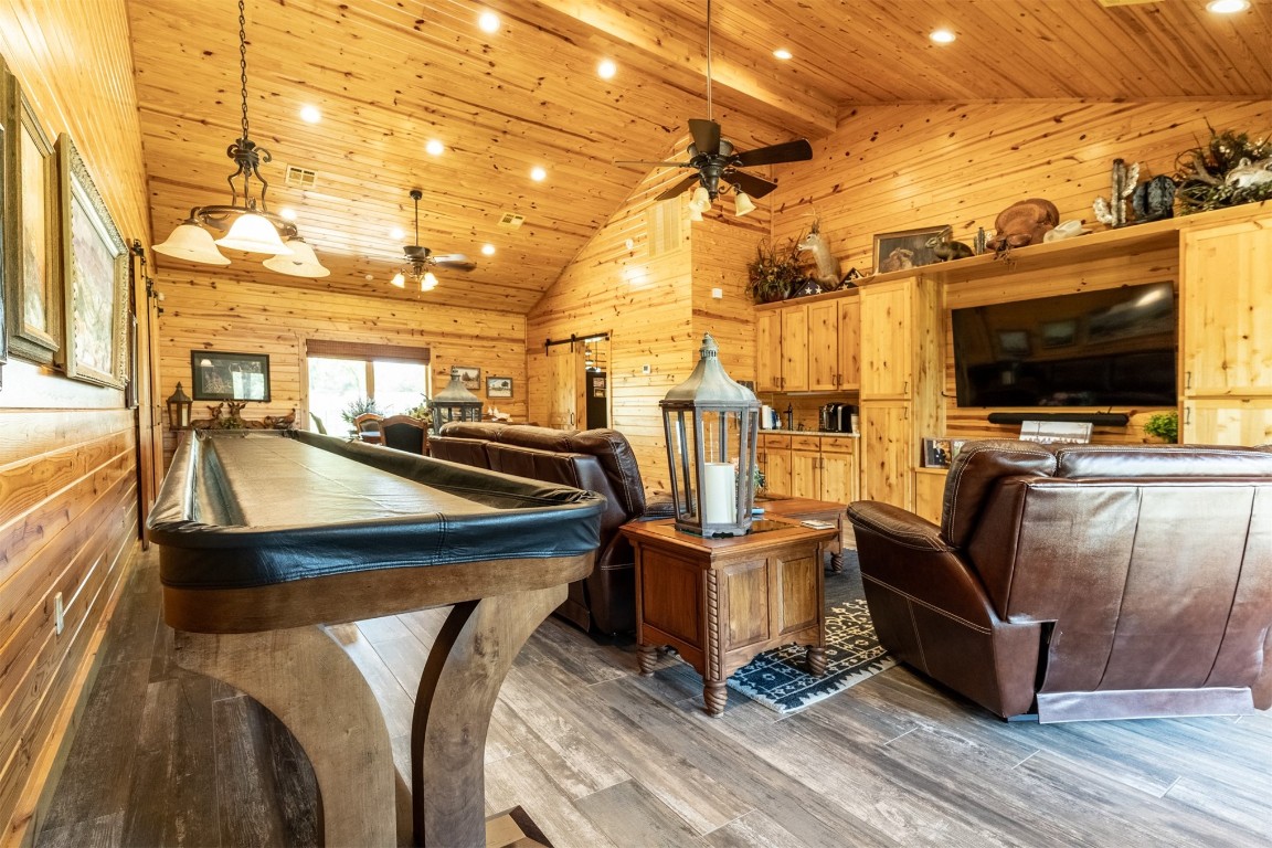 Address Hidden bedroom featuring wooden walls, high vaulted ceiling, dark hardwood / wood-style flooring, pool table, and wood ceiling