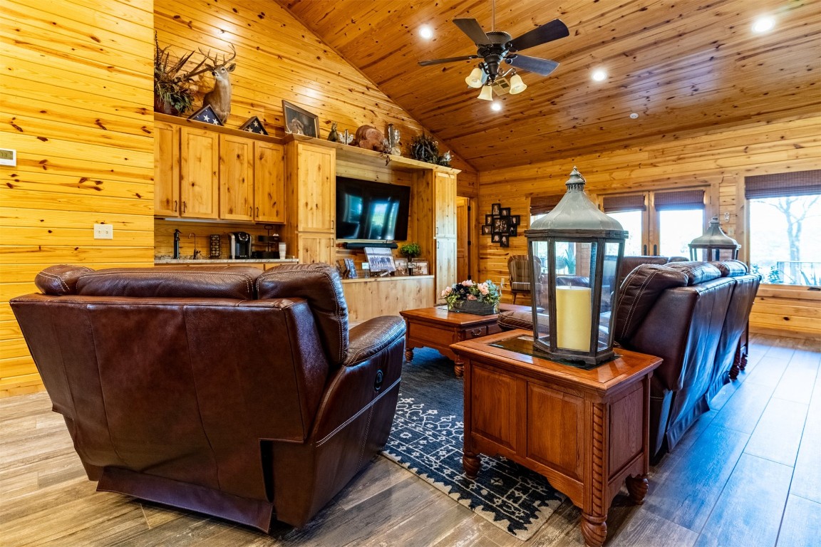 Address Hidden living room featuring wood ceiling, hardwood / wood-style floors, ceiling fan, and high vaulted ceiling