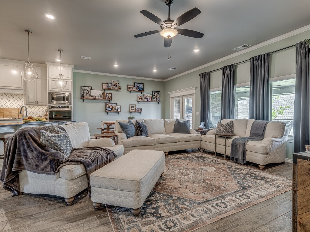 11812 Kylie Elizabeth Road, Yukon, OK 73099 living room with ornamental molding, ceiling fan, and a wealth of natural light