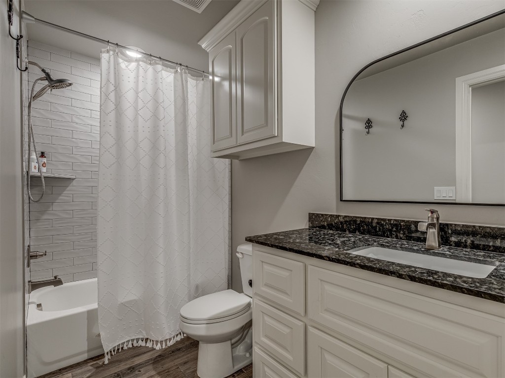 11812 Kylie Elizabeth Road, Yukon, OK 73099 full bathroom featuring wood-type flooring, vanity with extensive cabinet space, toilet, and shower / bathtub combination with curtain