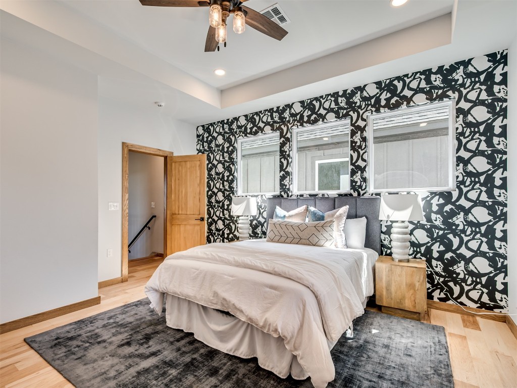 730 W Hurd Street, Edmond, OK 73003 bedroom featuring hardwood / wood-style floors, ceiling fan, and a tray ceiling