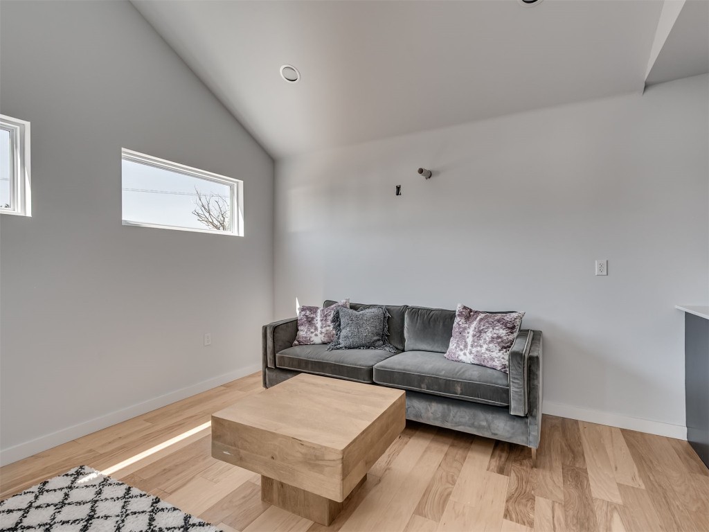 730 W Hurd Street, Edmond, OK 73003 living room featuring hardwood / wood-style flooring and vaulted ceiling