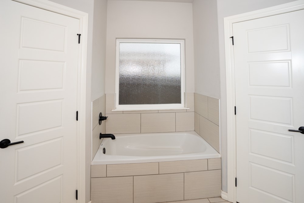 2508 Thornberry Lane, Yukon, OK 73099 bathroom featuring tiled tub