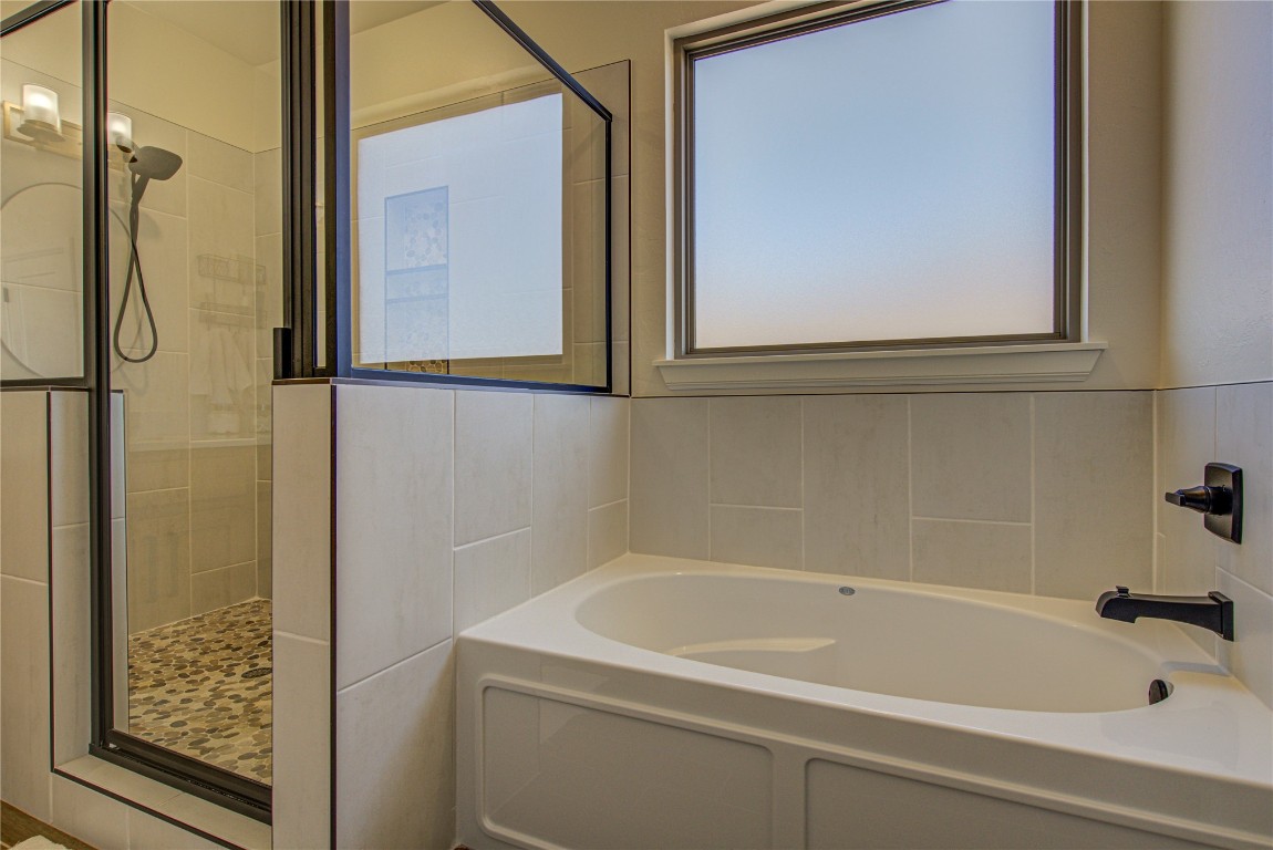 12656 Bridlewood Lane, Blanchard, OK 73010 bathroom featuring tile walls and independent shower and bath