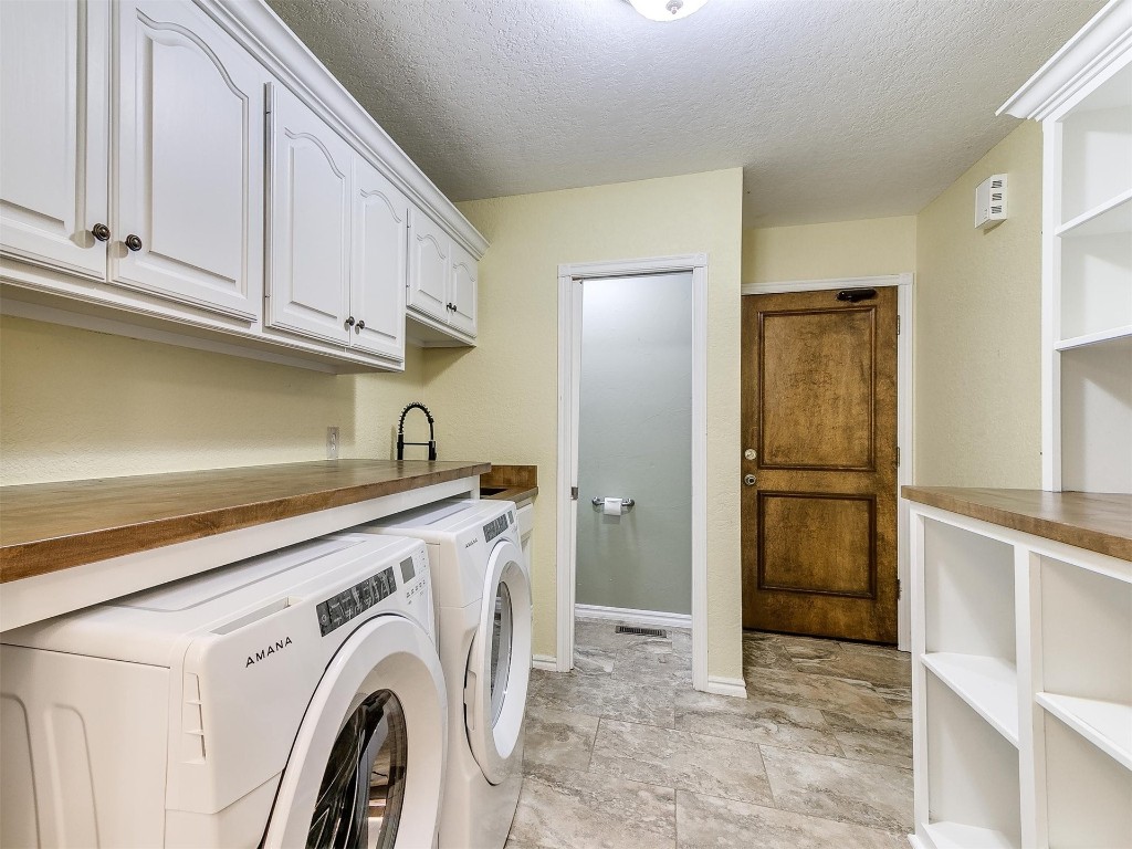 15512 Juniper Drive, Edmond, OK 73013 laundry area featuring independent washer and dryer, cabinets, light tile floors, and a textured ceiling