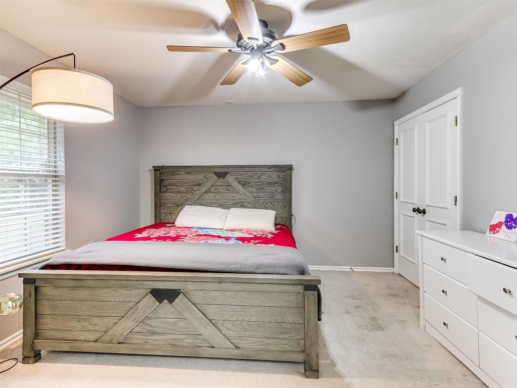 15512 Juniper Drive, Edmond, OK 73013 bedroom with light carpet and ceiling fan