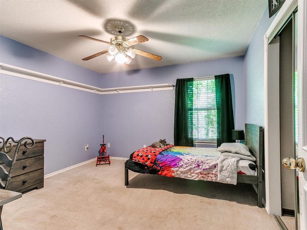 15512 Juniper Drive, Edmond, OK 73013 carpeted bedroom featuring ceiling fan and a textured ceiling