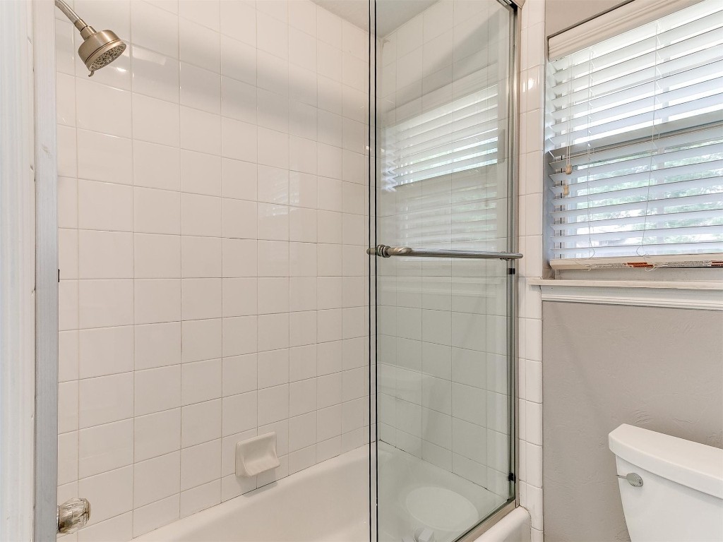 15512 Juniper Drive, Edmond, OK 73013 bathroom featuring shower / bath combination with glass door and toilet
