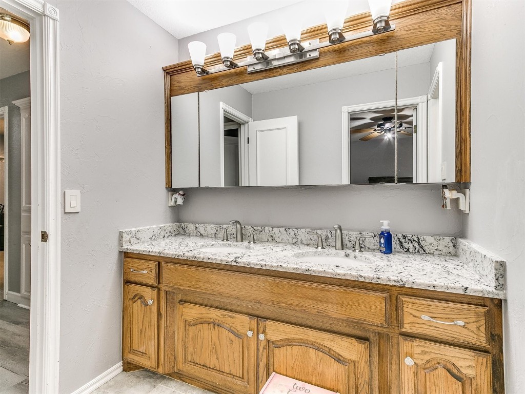 15512 Juniper Drive, Edmond, OK 73013 bathroom with dual sinks, ceiling fan, and vanity with extensive cabinet space