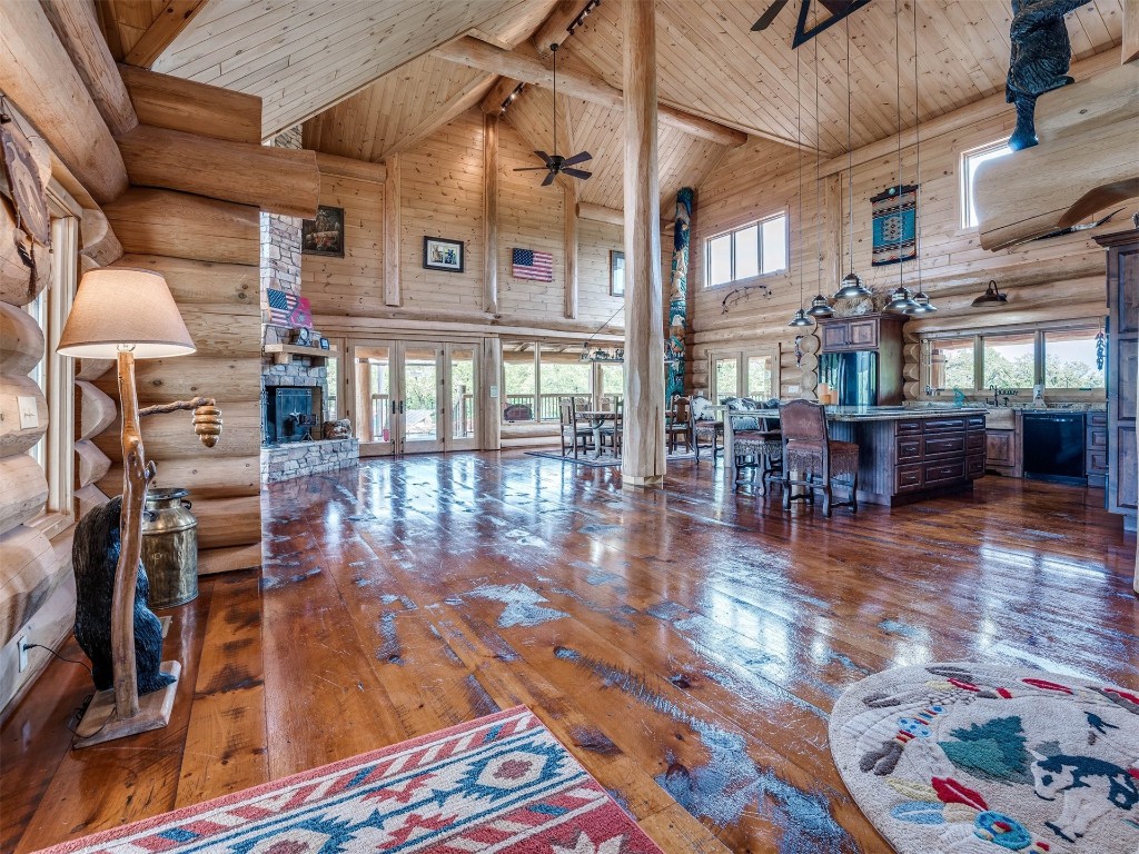 2050 S Henney Road, Guthrie, OK 73044 living room with high vaulted ceiling, wood-type flooring, and log walls