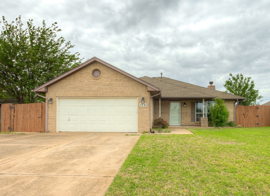 1321 Washington Circle, Moore, OK 73160 ranch-style home featuring a front yard and a garage