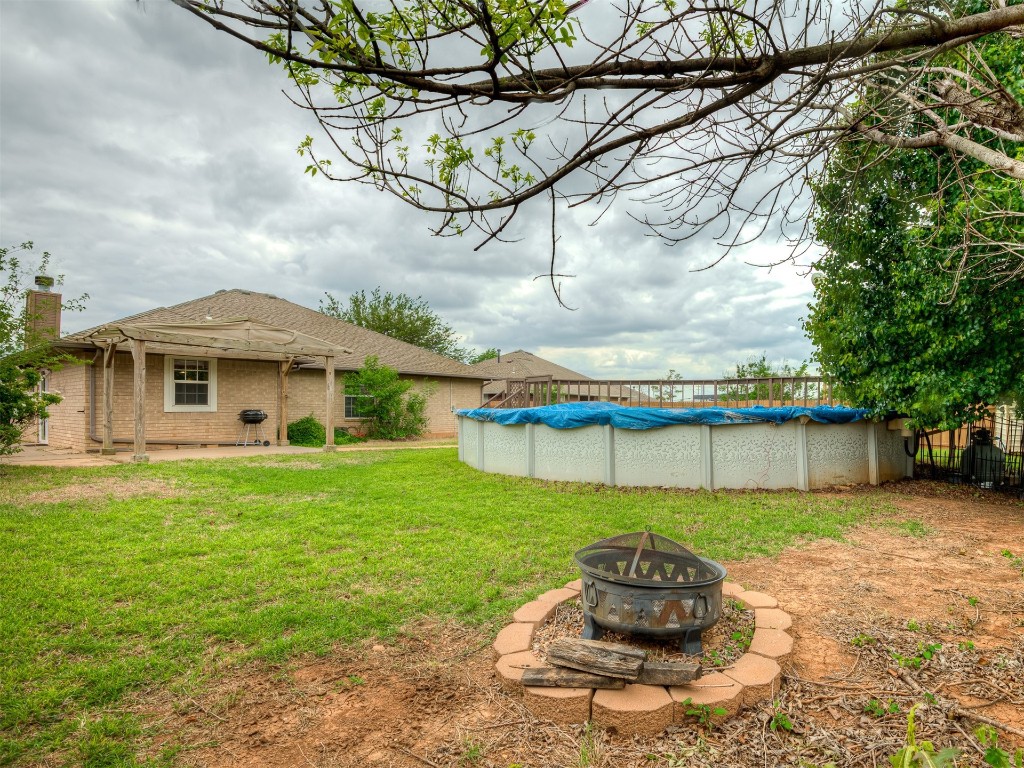 1321 Washington Circle, Moore, OK 73160 view of yard featuring a patio, a fire pit, and a covered pool