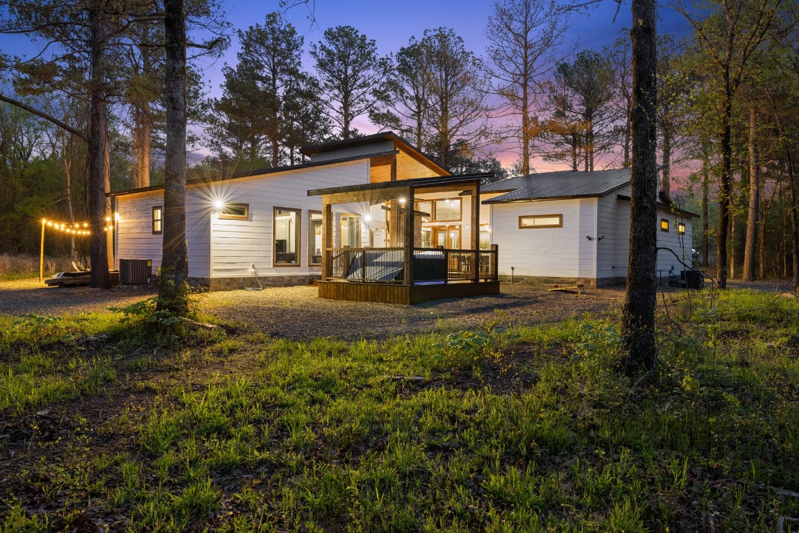 292 Xpress Lane, Broken Bow, OK 74728 deck at dusk featuring an outdoor living space with a fireplace