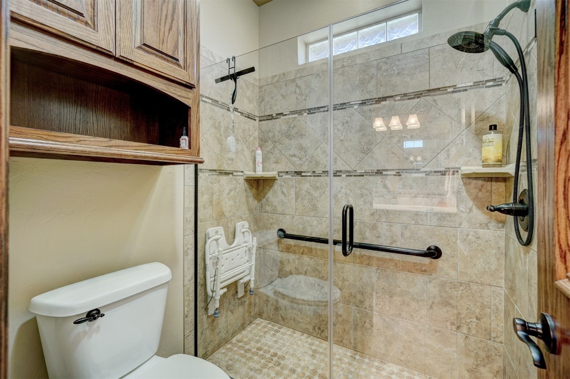7829 E 2nd Street, Edmond, OK 73034 bathroom featuring a shower with door and toilet