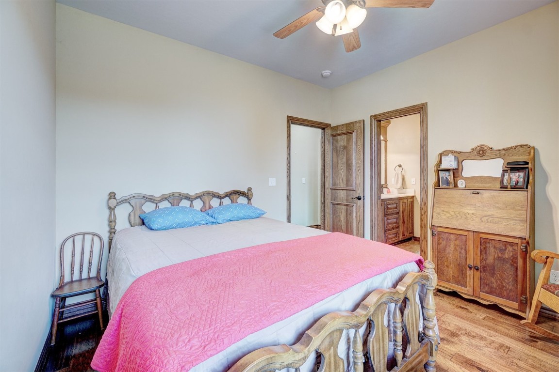 7829 E 2nd Street, Edmond, OK 73034 bedroom featuring ceiling fan, hardwood / wood-style flooring, and ensuite bathroom
