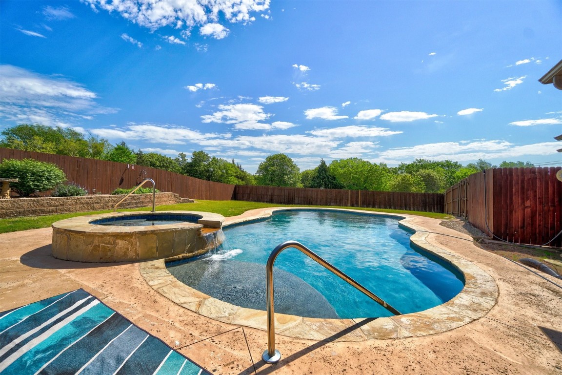 7829 E 2nd Street, Edmond, OK 73034 view of pool featuring pool water feature, an in ground hot tub, and a patio