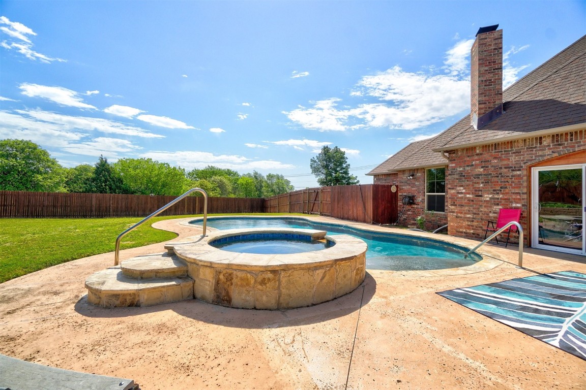 7829 E 2nd Street, Edmond, OK 73034 view of swimming pool featuring a patio area and an in ground hot tub