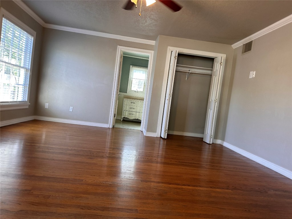 4311 N Georgia Avenue, Oklahoma City, OK 73118 unfurnished bedroom with dark hardwood / wood-style flooring, multiple windows, and ceiling fan