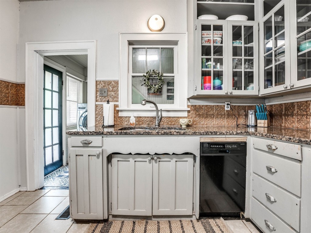 418 N Park Street, Guthrie, OK 73044 kitchen featuring backsplash, sink, light tile floors, and black dishwasher