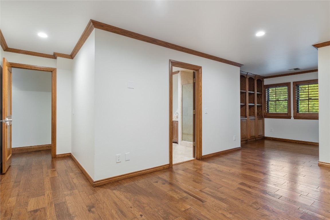 18809 Wolf Creek Drive, Edmond, OK 73003 unfurnished room featuring wood-type flooring and ornamental molding