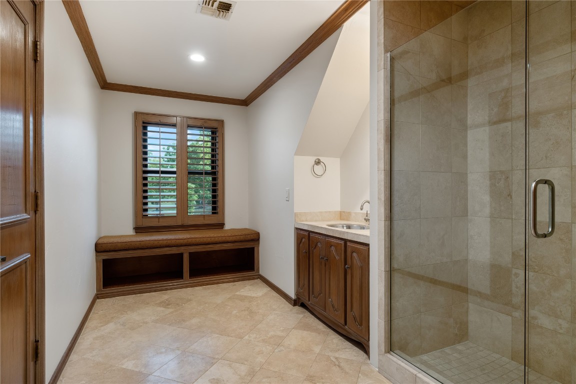 18809 Wolf Creek Drive, Edmond, OK 73003 bathroom with a shower with shower door, vanity, crown molding, and tile flooring