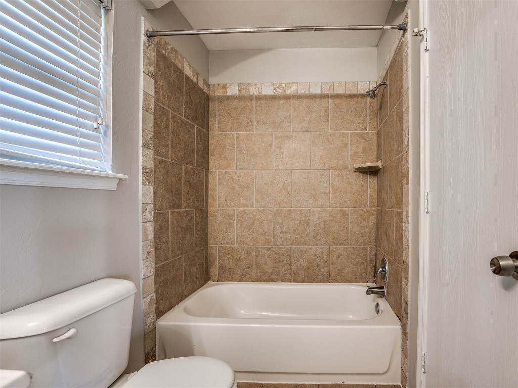 8613 SW 46th Place, Oklahoma City, OK 73179 bathroom featuring tiled shower / bath combo and toilet