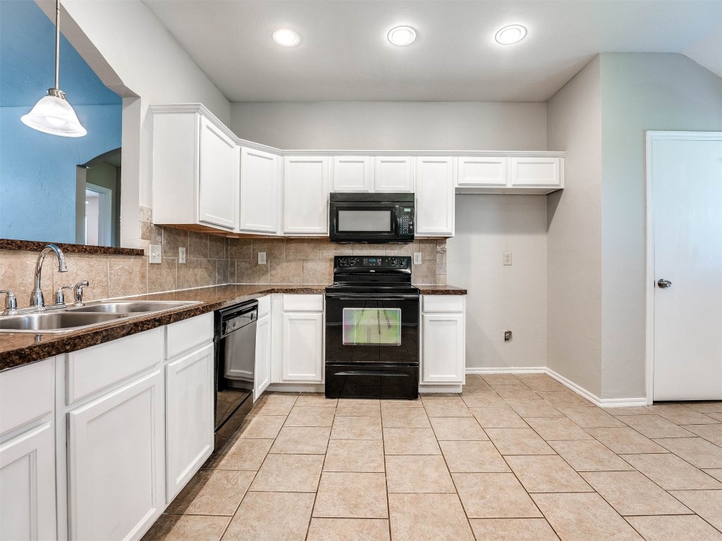 8613 SW 46th Place, Oklahoma City, OK 73179 kitchen featuring sink, light tile flooring, tasteful backsplash, and black appliances