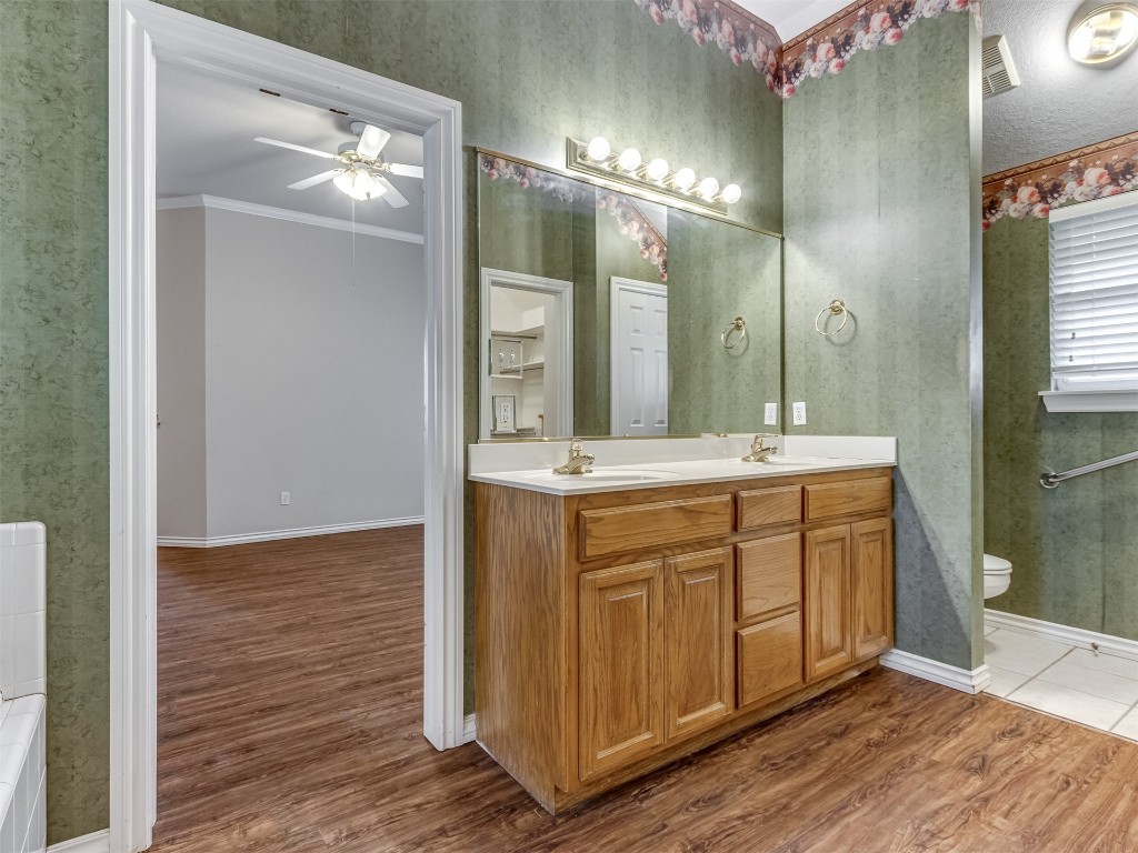 16605 Farmington Way, Edmond, OK 73012 bathroom with dual bowl vanity, toilet, ceiling fan, and hardwood / wood-style floors