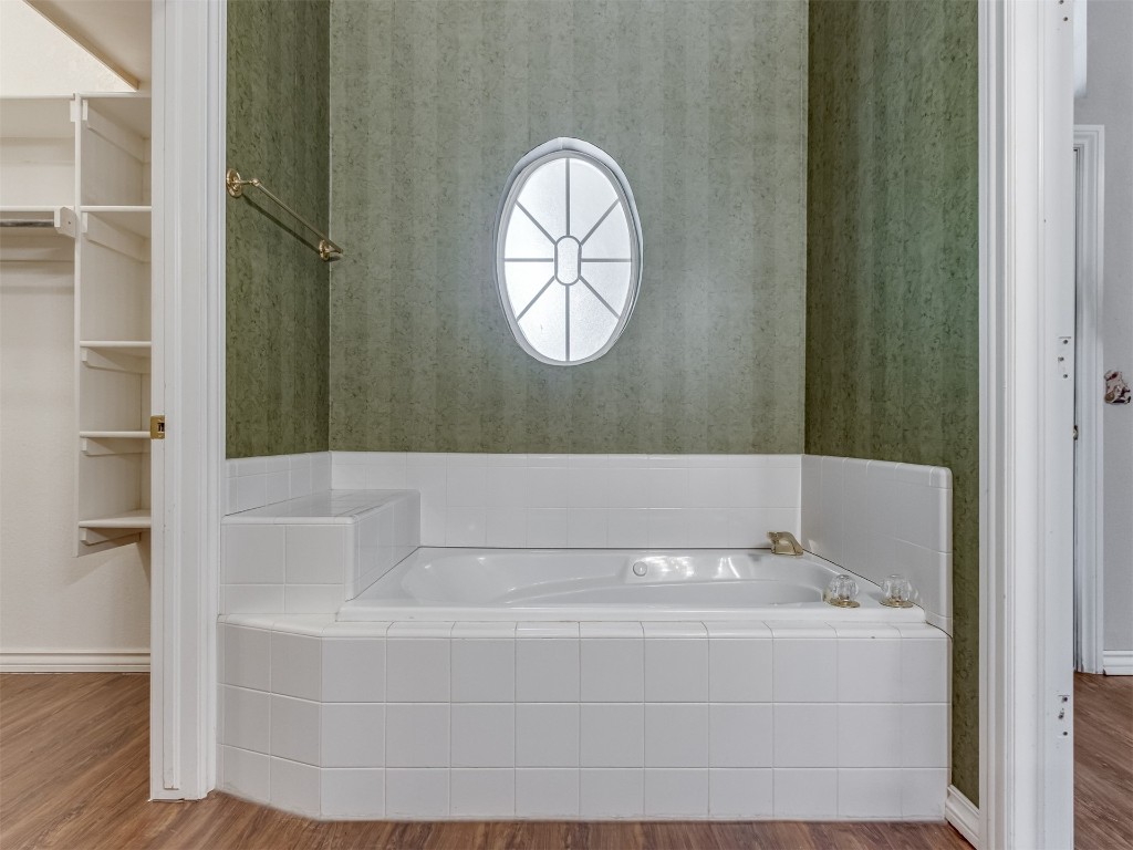 16605 Farmington Way, Edmond, OK 73012 bathroom with wood-type flooring and tiled bath