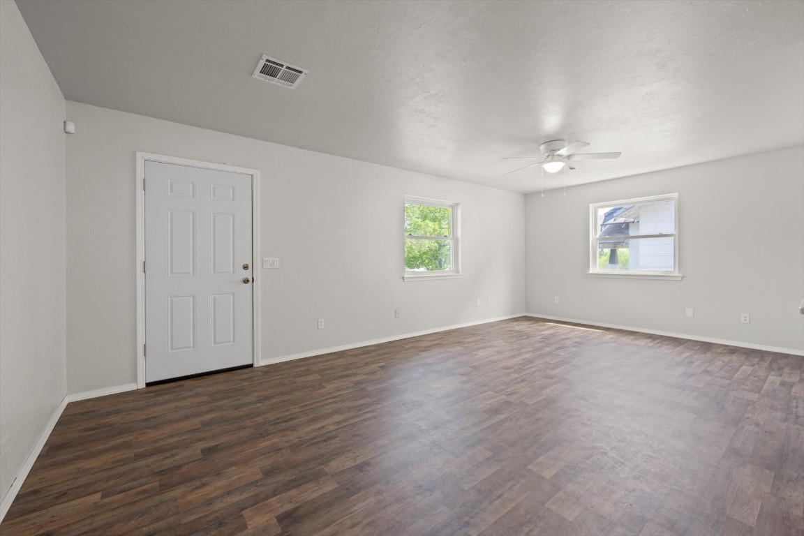 1619 W Oklahoma Avenue, Guthrie, OK 73044 empty room with ceiling fan and dark wood-type flooring