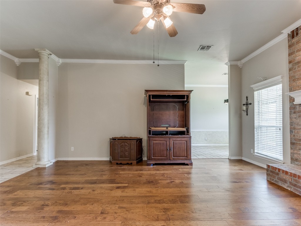 12109 Dalton Drive, Oklahoma City, OK 73162 unfurnished living room featuring hardwood / wood-style floors, ornate columns, ceiling fan, and ornamental molding
