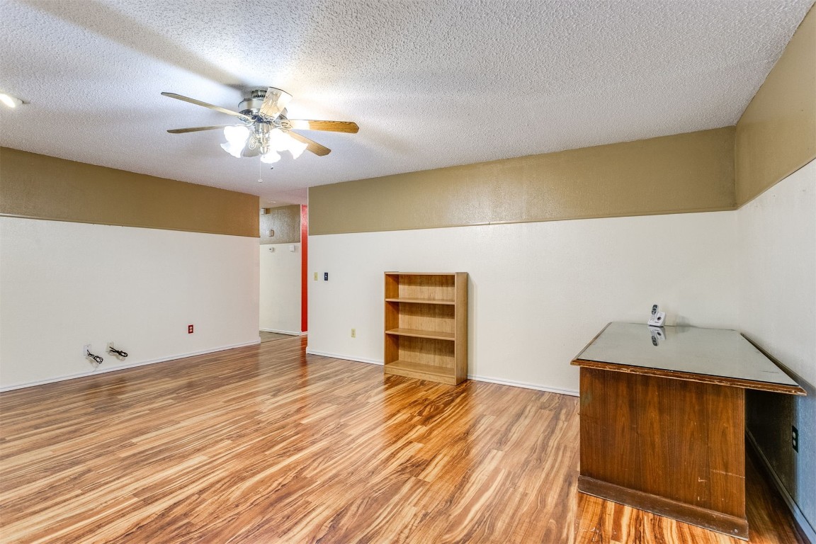 224 N Westminster Way, Mustang, OK 73064 unfurnished room featuring a textured ceiling, ceiling fan, and light hardwood / wood-style floors