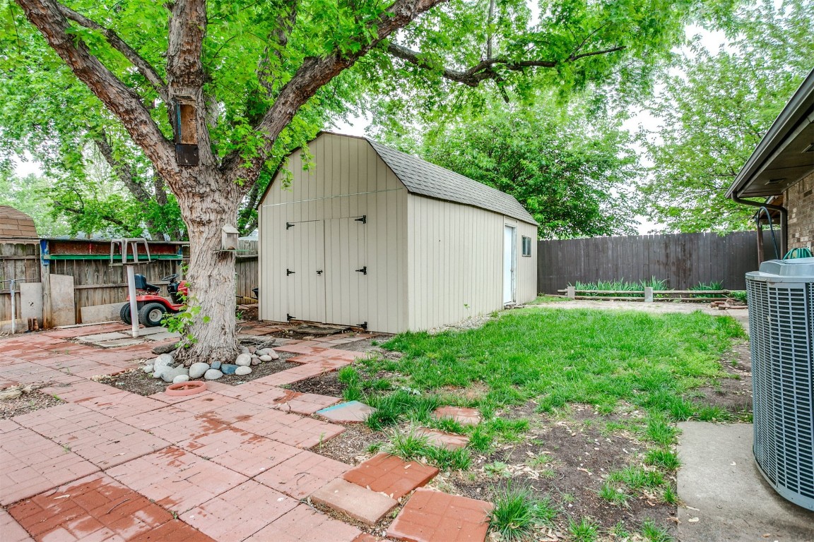 224 N Westminster Way, Mustang, OK 73064 view of yard featuring central AC unit, a patio, and a storage shed
