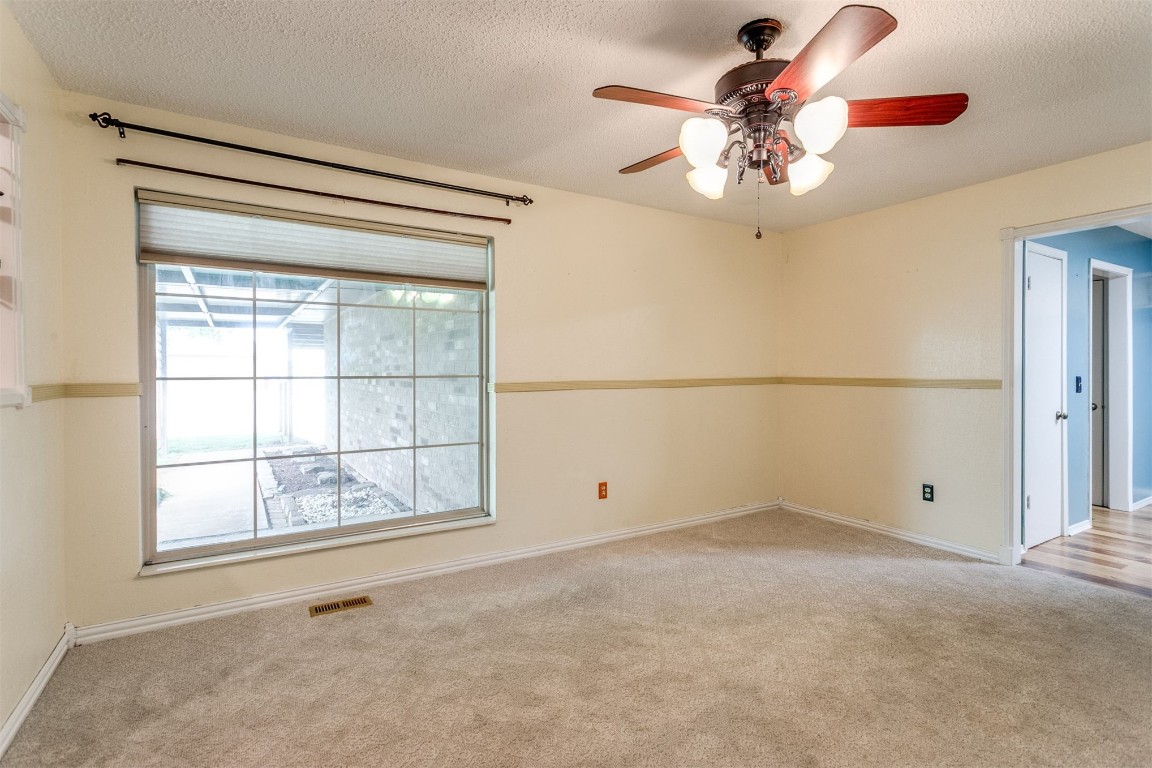 224 N Westminster Way, Mustang, OK 73064 unfurnished room with a textured ceiling, ceiling fan, and carpet flooring