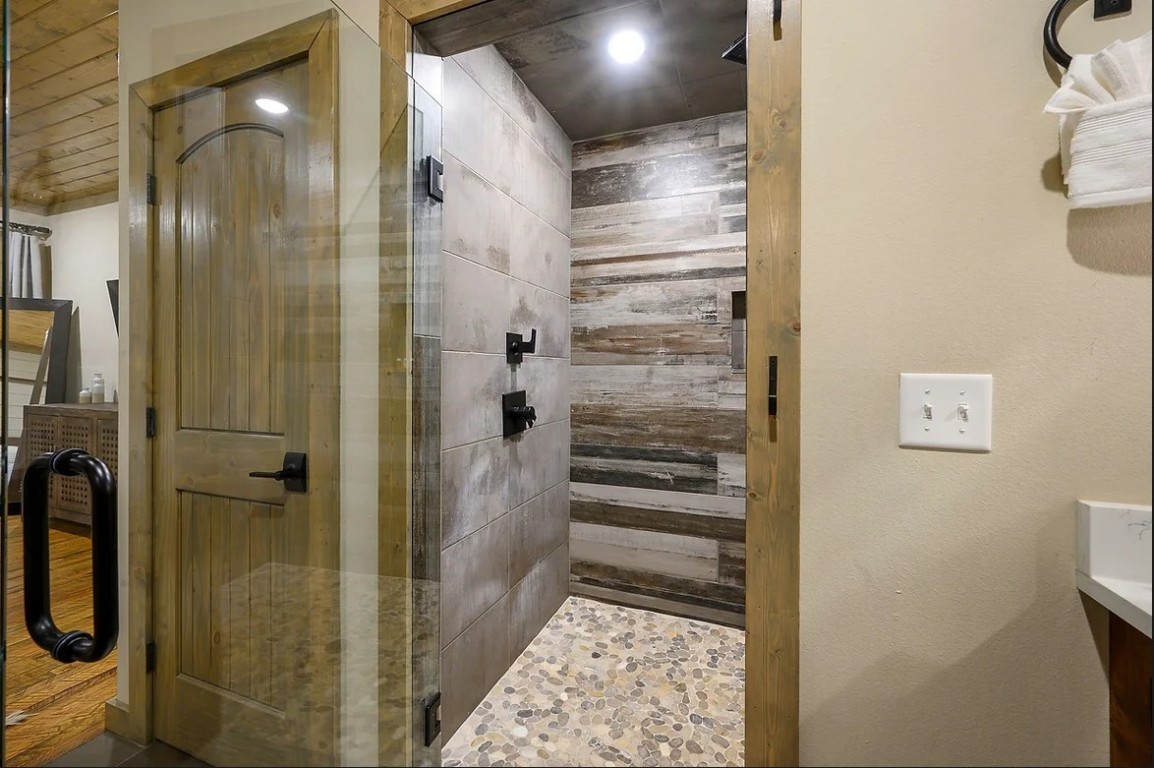 28 Silent Stream Trail, Broken Bow, OK 74728 bathroom featuring wood walls, an enclosed shower, and vanity