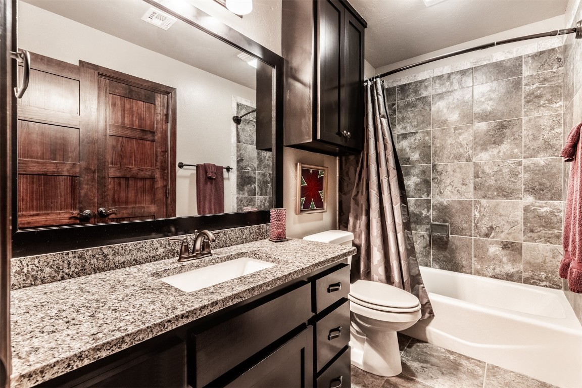2709 Mesquite Lane, Edmond, OK 73034 full bathroom with large vanity, shower / bath combination with curtain, tile floors, and toilet