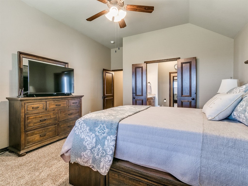 1900 Alexander Way, Yukon, OK 73099 bedroom featuring light colored carpet, lofted ceiling, and ceiling fan