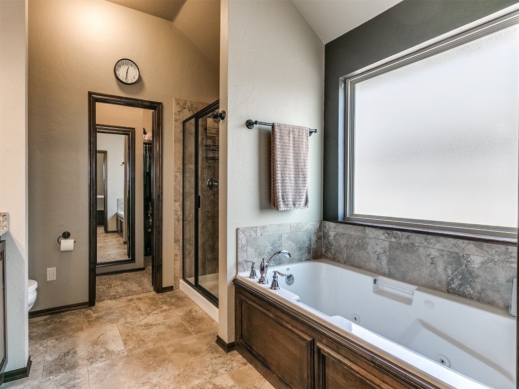 1900 Alexander Way, Yukon, OK 73099 full bathroom featuring lofted ceiling, toilet, tile floors, and plus walk in shower