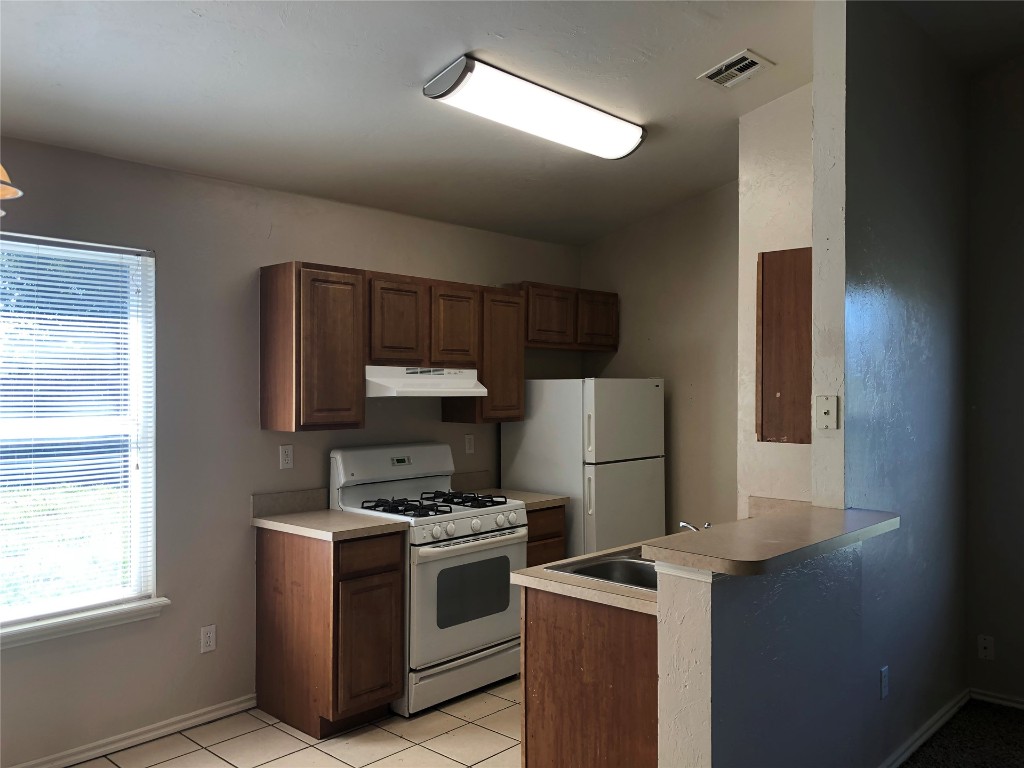 Address Hidden kitchen featuring white appliances, sink, and light tile floors