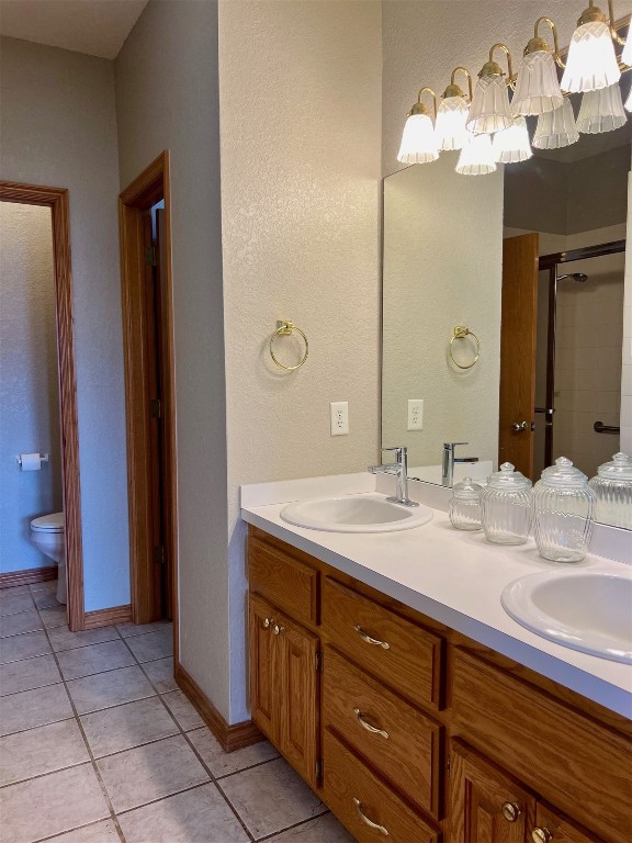 180 N Lakeside Terrace, Mustang, OK 73064 bathroom with tile flooring, toilet, and dual vanity