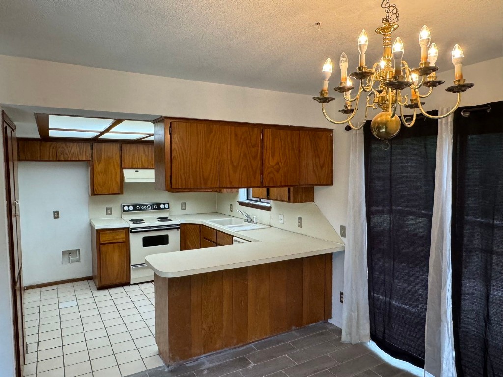 1810 Remington Circle, Shawnee, OK 74801 kitchen with kitchen peninsula, pendant lighting, tile flooring, and white electric range
